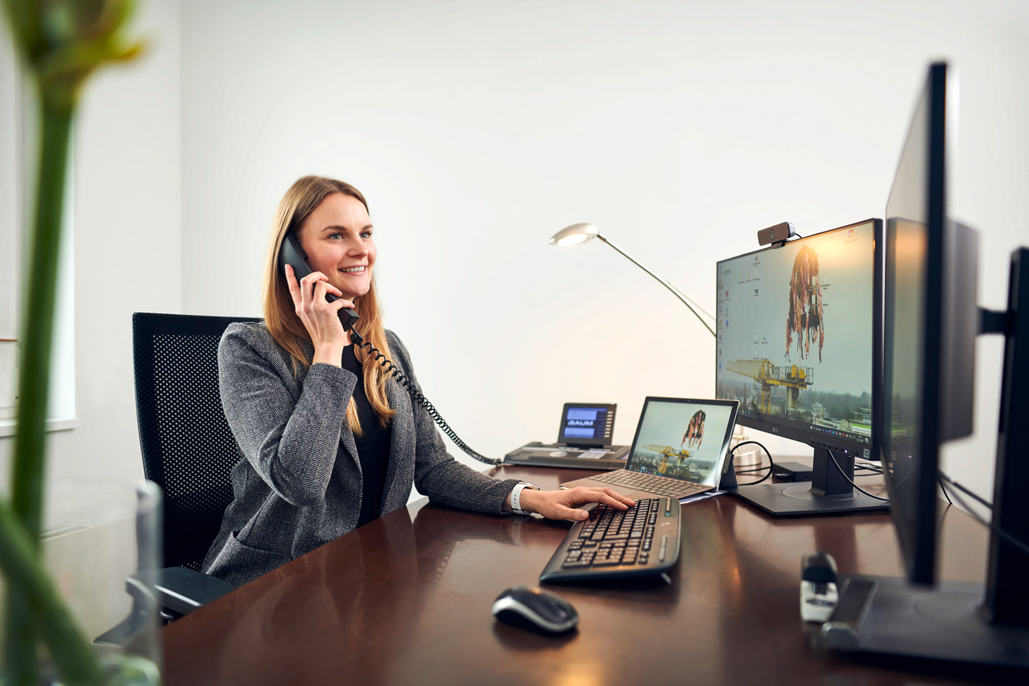Mitarbeiterin sitzt telefonierend am Schreibtisch